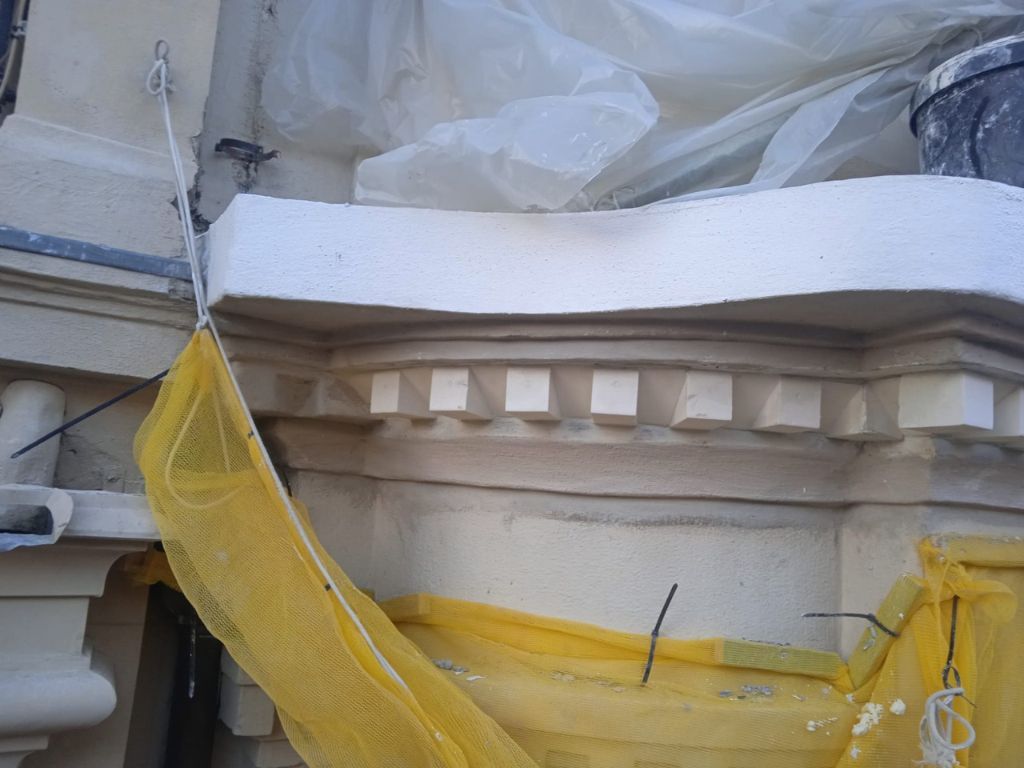 detalle de remate de molduras en pilar circular para la rehabilitación de fachada terminada en edificio histórico en Bilbao