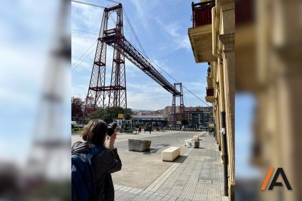 Amaya gerente Insignia Rehabilitación y Arquitectura sacando fotos de la fachada de arenisca recién restaurada en Getxo