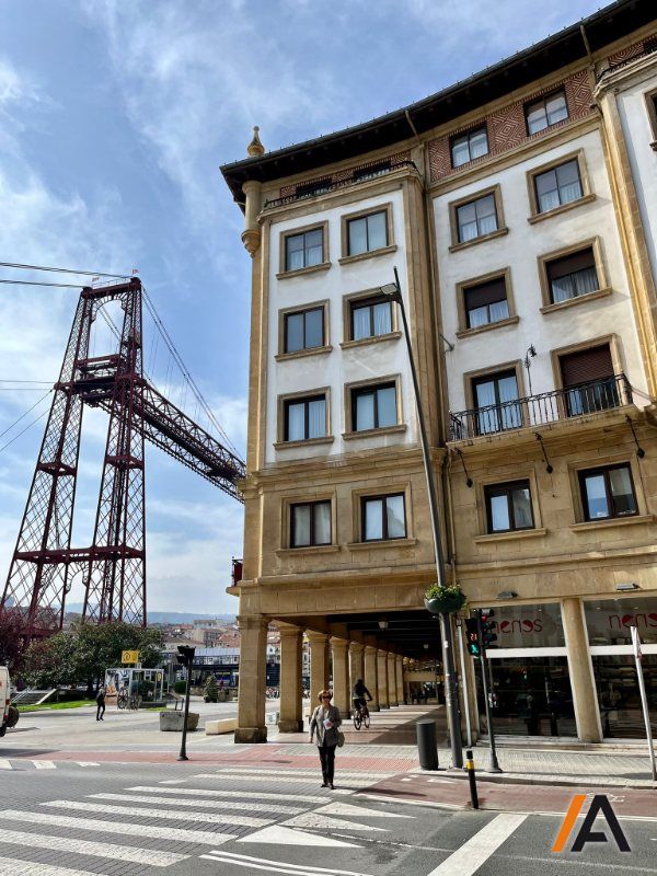 Fachada de hormigón y arenisca junto a Puente Bizkaia recientemente restaurada por Insignia Arquitectura y Rehabilitación