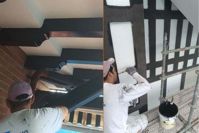 operario pintando las partes de madera de la fachada